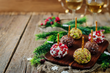 Variation of goat cheese balls appetizer with pistachio, pomegranate and flax seeds