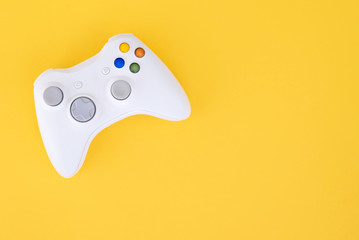 Gamepad is isolated on a yellow background. Gaming competition. White joystick on yellow...