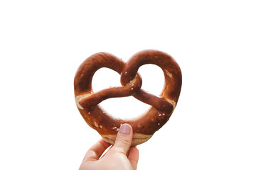 Traditional German pretzel in hand isolated on white background.