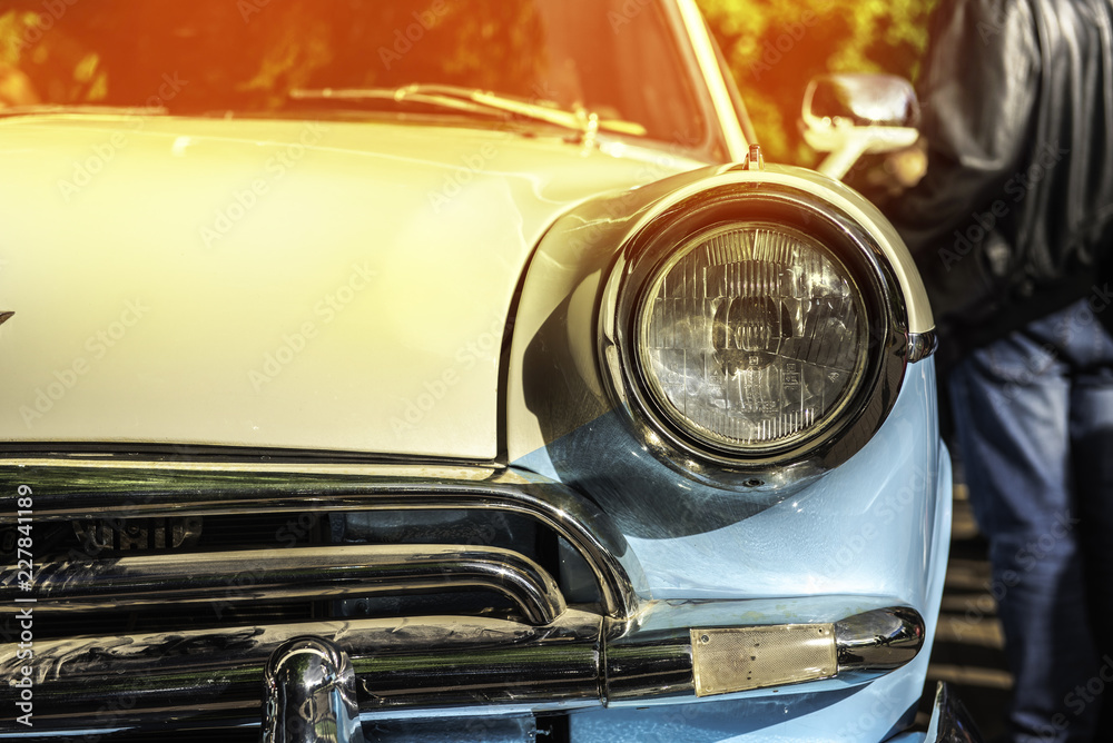 Wall mural old classical car of white-blue color. macro front view. sunshine