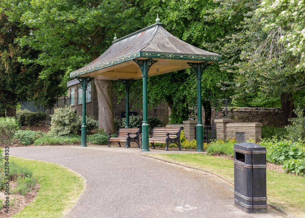 Wall mural two empty benches in the park under the roof. park in sheffield, england.