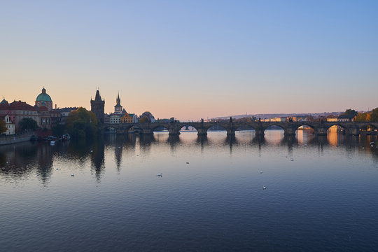 Landscape Picture of Charles bridge over Vltava river in Prague, capitol of Czech Republic in the morning during the sunrise, famous gothic style architecture in europe.