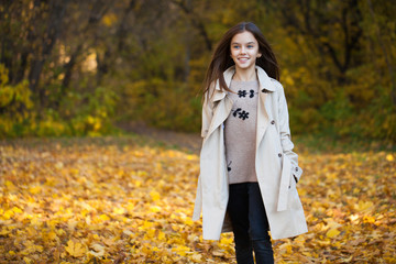 Happy young little girl in beige coat