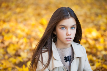 Happy young little girl in beige coat