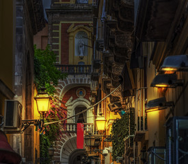 Narrow alley with Duomo steeple on the background in world famous Sorrento at night
