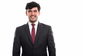 Studio shot of young happy Persian businessman smiling