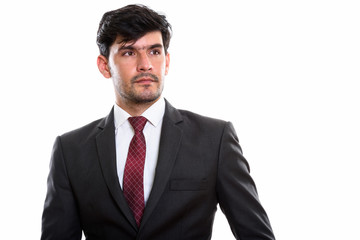Studio shot of young Persian businessman thinking while looking 