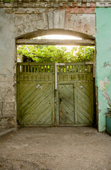 Green wooden gates. Vintage looking exterior of old building in Russia. Old house entrance
