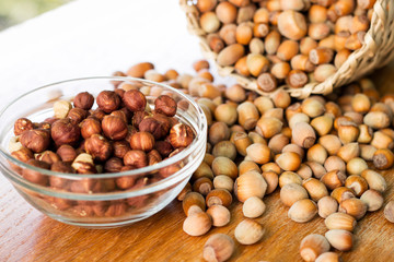 Hazelnuts in a wicker basket on old wooden table 