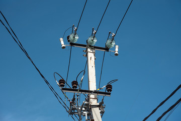 pole with electrical and telephone wires against the blue sky. internet cable light guide....