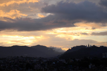 Fototapeta premium The romantic sunset view of Swayambhunath Stupa from the rooftop in Kathmandu