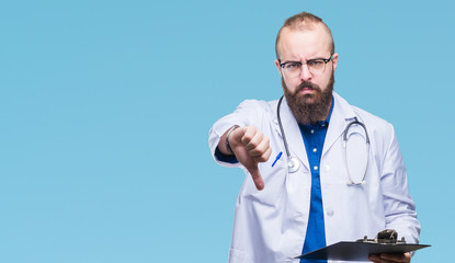 Young doctor man holding clipboard over isolated background with angry face, negative sign showing dislike with thumbs down, rejection concept