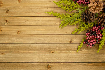 Rustic wood background with berries, pine cones, and leaves
