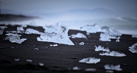 Shards of glacial ice scattered on black sand at Diamond Beach, Iceland