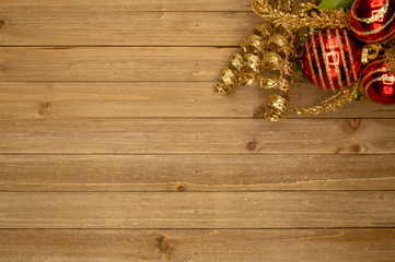 Holiday wood background with festive red ball ornament and golden accent