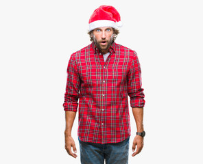 Handsome hispanic man model wearing santa claus christmas over isolated background afraid and shocked with surprise expression, fear and excited face.