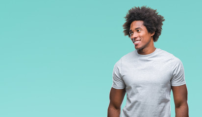 Afro american man over isolated background looking away to side with smile on face, natural expression. Laughing confident.