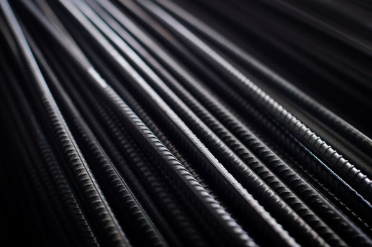 closeup of hard rods division rebars, used on stacked construction concrete background. industrial professional equipment pattern, stiff macro perspective image for reinforcement and construction.