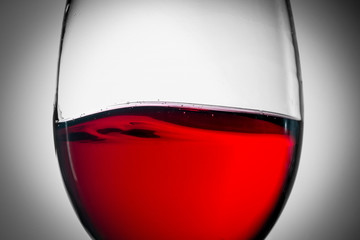 Red wine splash in the wineglass close-up macro texture background. Vintage old retro style view. Soft focus.