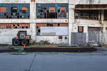 Side of abandoned factory with blown out windows