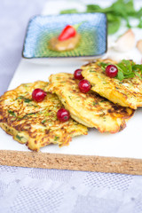 Vegetable zucchini pancakes, served with fresh herbs and garlic yogurt sauce, vegetarian  fritters 
