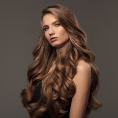 Beautiful woman with brown curly hair. Hairstyle.