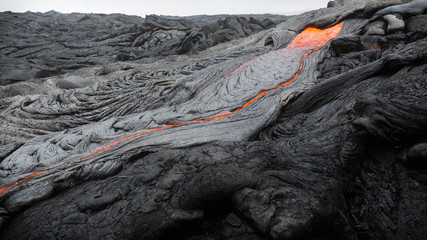 Molten magma breaking through the ground of the lava fields of Puu Oo, Big Island, Hawaii.