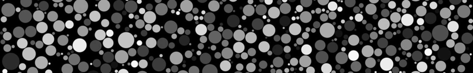 Abstract horizontal banner of circles of different sizes in shades of gray colors on black background