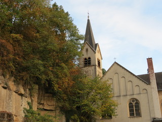 Fototapeta premium Old church in Luxembourg lower city, next to natural rock wall, in autumn