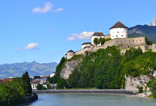 Castle on a rock above river with blues sky in the background