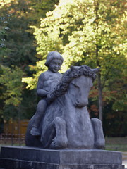 Fototapeta na wymiar Stone figure, weathered, child on horse, bridge town Hamm in Germany