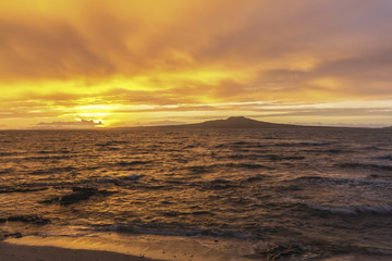 Fototapeta premium Landscape Scenery during Sunrise Time at Takapuna Beach, Auckland New Zealand; View to Rangitoto Island; Rough Seas