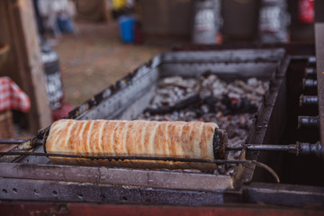 The baking of Kurtoskalacs, the traditional hungarian spit cake, in a pastry shop. Festival, Kurtoskalacs Fesztival in Budapest, Hungary.
