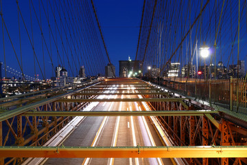 Fototapeta na wymiar New York skyline, Brooklyn Bridge traffic at night, Manhattan buildings and skyscrapers