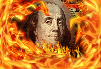 Conceptual finance image of burning dollar bill and fire flames