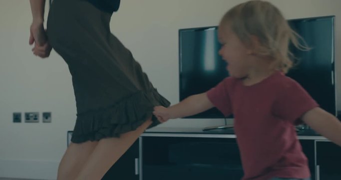 Mother and toddler dancing around in city apartment