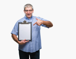 Handsome senior inspector man holding clipboard over isolated background very happy pointing with hand and finger