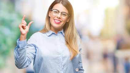 Young beautiful business woman wearing glasses over isolated background smiling and confident gesturing with hand doing size sign with fingers while looking and the camera. Measure concept.