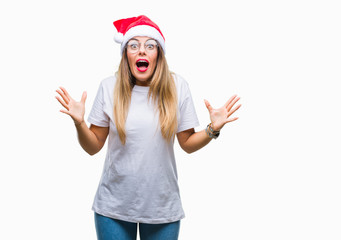 Obraz na płótnie Canvas Young beautiful woman wearing christmas hat over isolated background celebrating crazy and amazed for success with arms raised and open eyes screaming excited. Winner concept