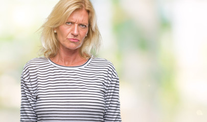 Middle age blonde woman over isolated background skeptic and nervous, frowning upset because of problem. Negative person.