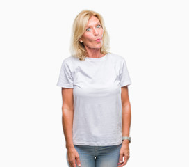 Fototapeta premium Middle age blonde woman over isolated background making fish face with lips, crazy and comical gesture. Funny expression.