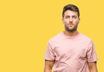 Fototapeta premium Young handsome man over isolated background with serious expression on face. Simple and natural looking at the camera.