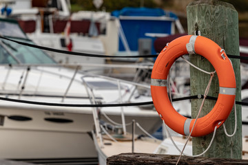 orange life preserver with boats blurred in back ground.