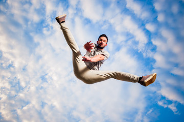 Parkour guy jumping below blue sky