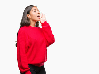 Young beautiful arab woman wearing winter sweater over isolated background shouting and screaming loud to side with hand on mouth. Communication concept.