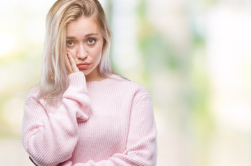 Fototapeta na wymiar Young blonde woman wearing winter sweater over isolated background thinking looking tired and bored with depression problems with crossed arms.