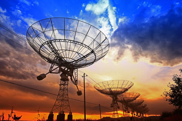 Fototapeta na wymiar The silhouette of a radio telescope observatory