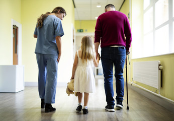 Nurse walking a patient down the hallway