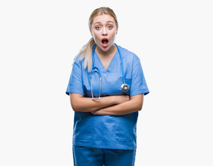 Young blonde surgeon doctor woman over isolated background afraid and shocked with surprise expression, fear and excited face.