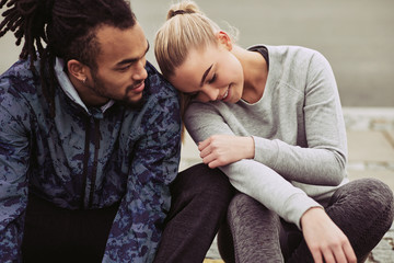 Smiling young couple taking a break from jogging together